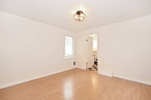 a living room with a hard wood floor and white walls