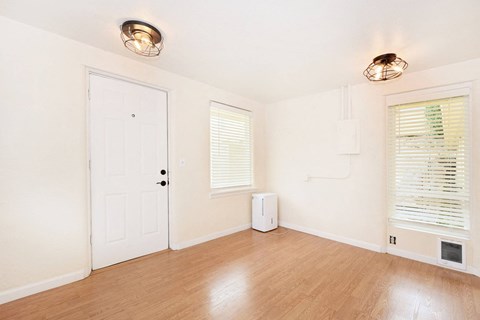 an empty living room with white walls and wood floors