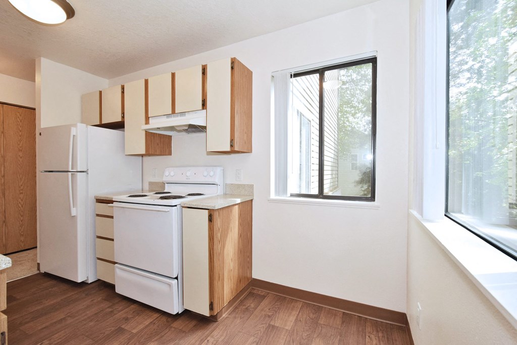 a kitchen with white appliances and wooden cabinets