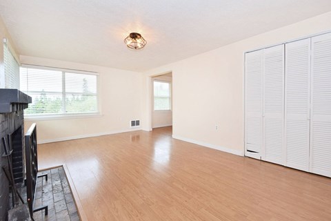 an empty living room with wood flooring and a fireplace