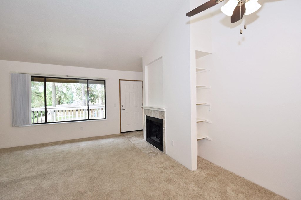 a living room with a fireplace and a ceiling fan