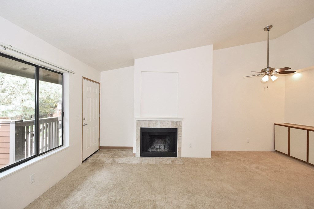 a living room with a fireplace and a large window