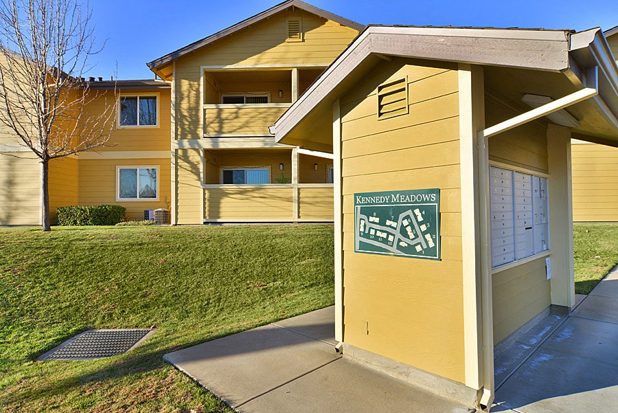 a small yellow building with a sign on the side of it