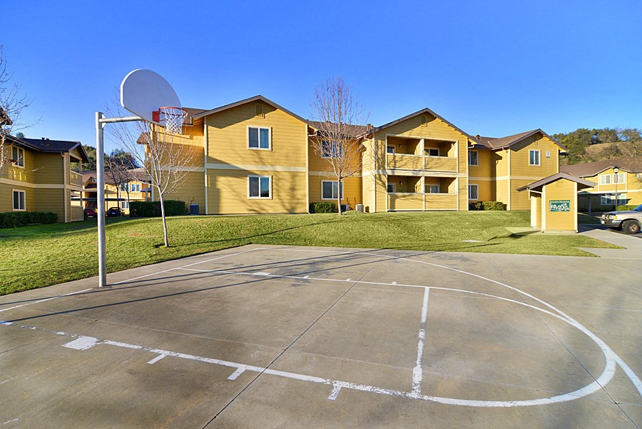 a basketball court in front of yellow apartment buildings