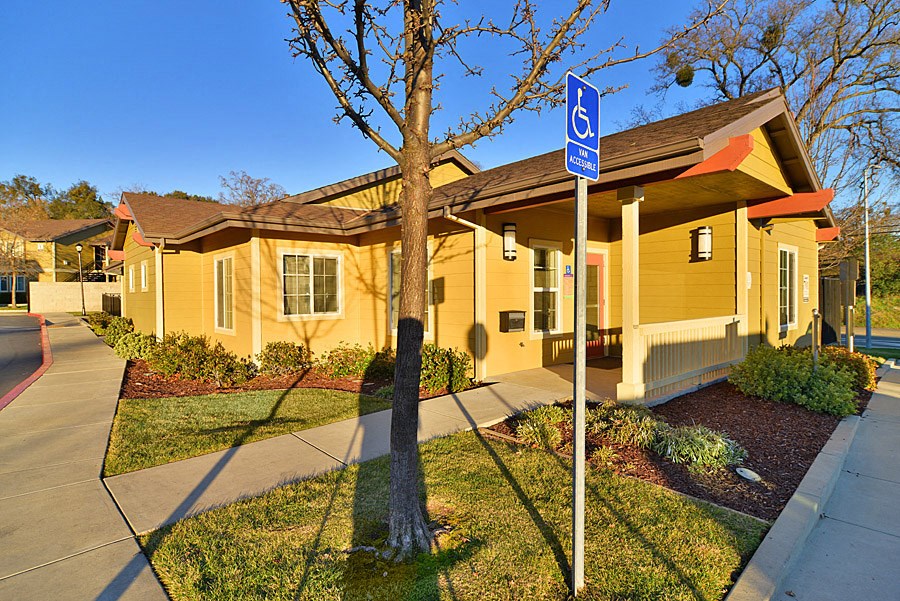 a yellow house with a street sign in front of it