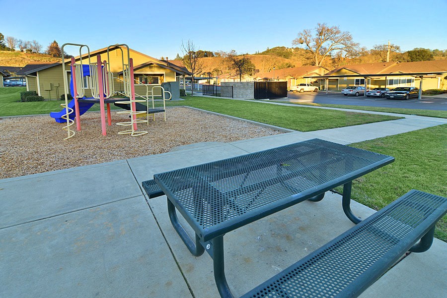 a picnic table in front of a playground