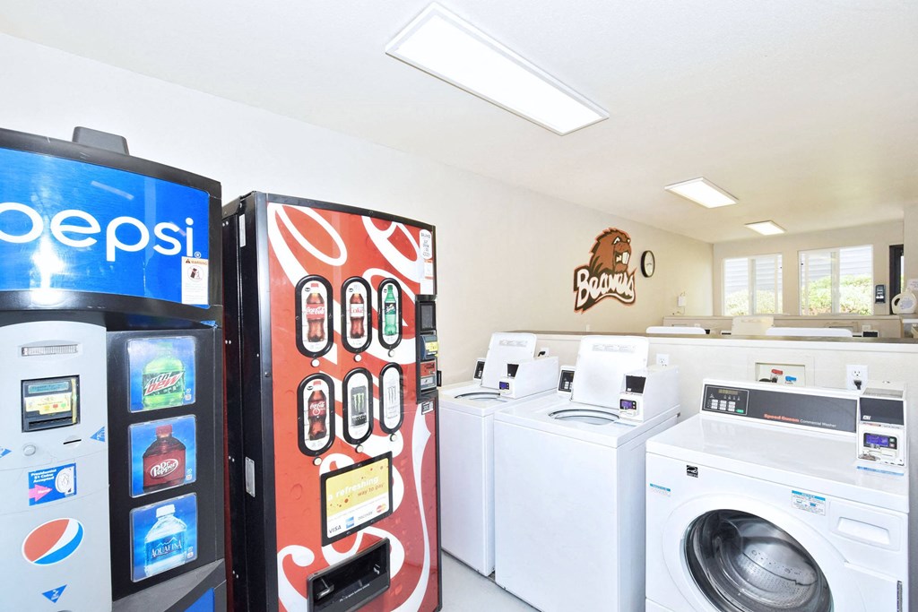 a washer and dryer in a laundry room with a vending machine