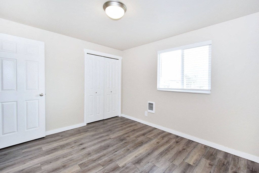 an empty living room with white walls and wood flooring