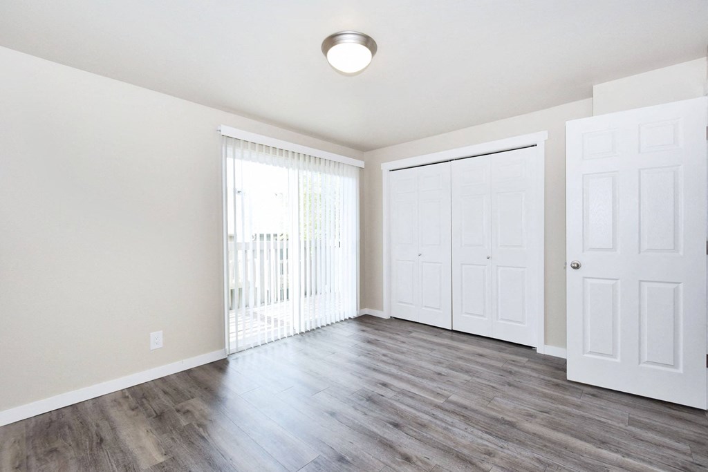 an empty living room with white walls and wood flooring