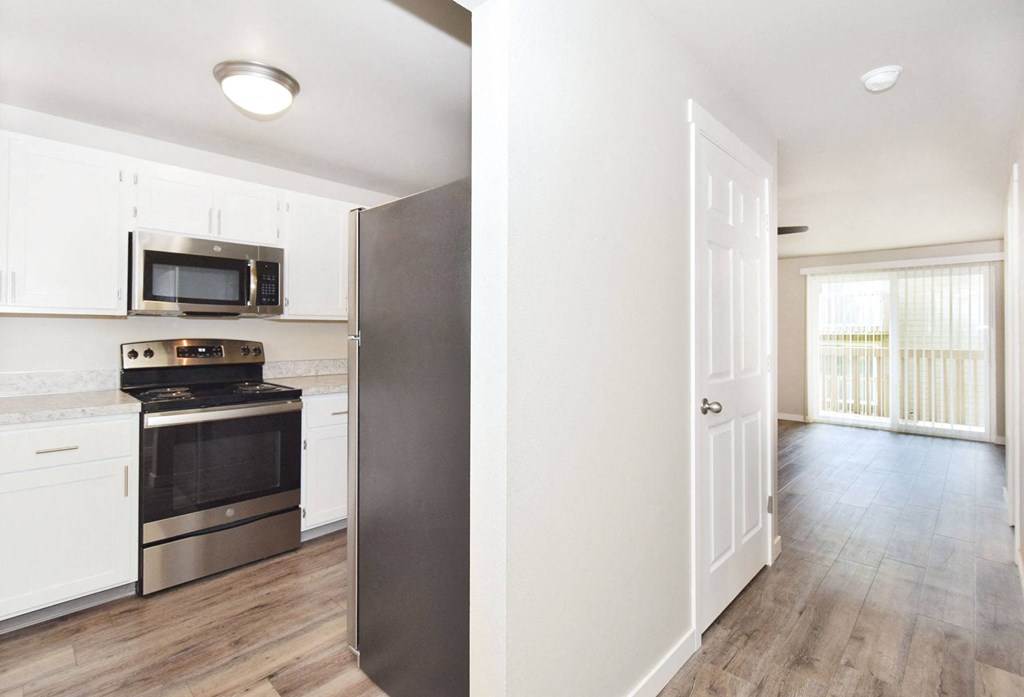 a renovated kitchen with white cabinets and a black stove