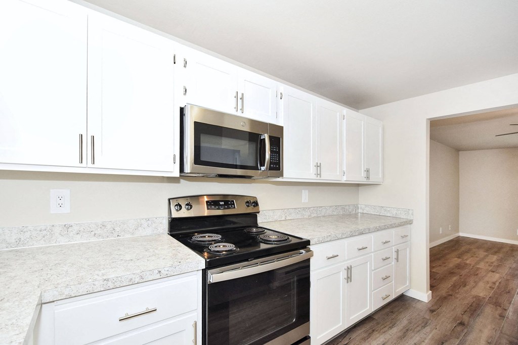a kitchen with white cabinets and a stove and a microwave