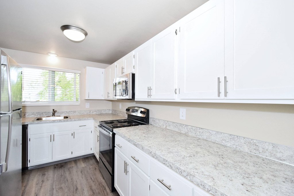 a kitchen with white cabinets and stainless steel appliances