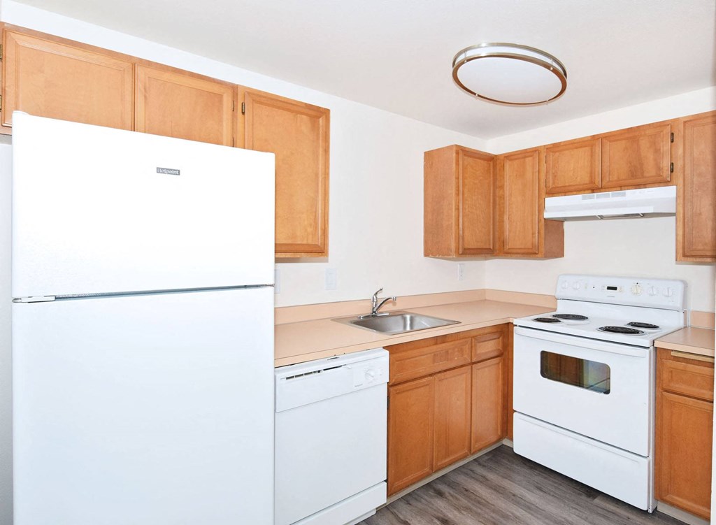 a kitchen with white appliances and wooden cabinets