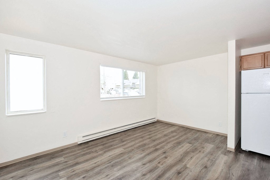 an empty room with a refrigerator and a window
