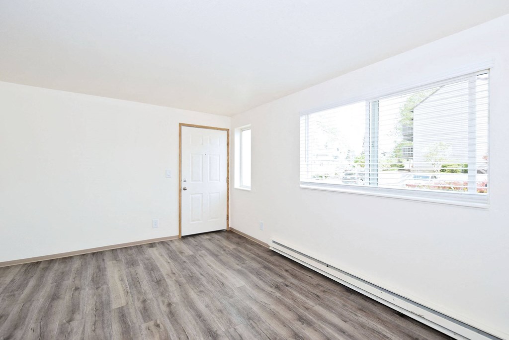an empty room with white walls and a window