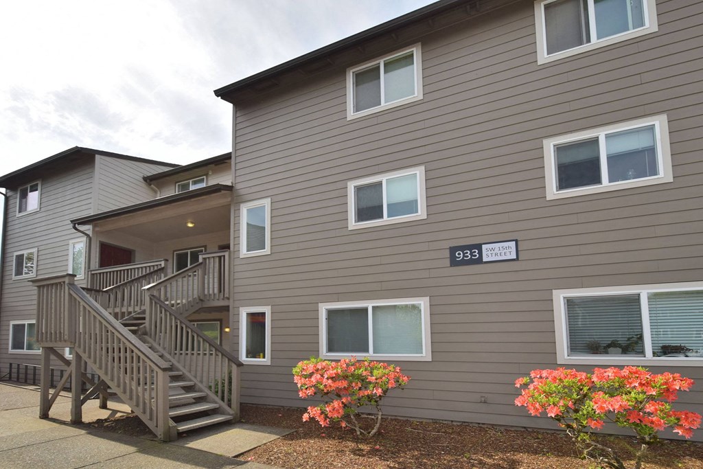 the exterior of a building with stairs and flowers