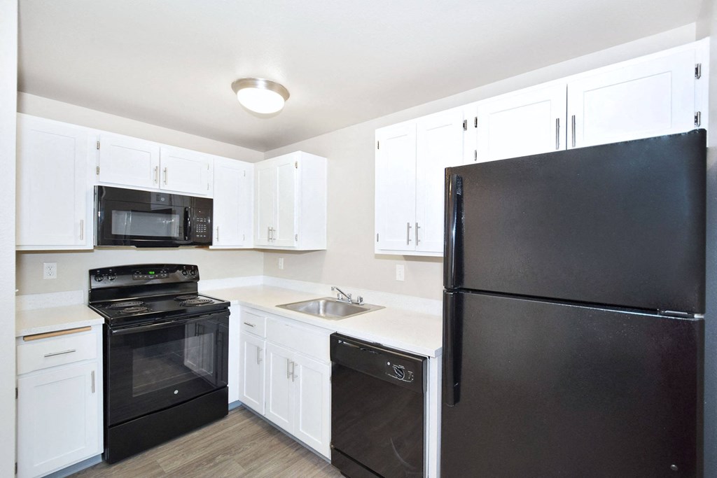 a kitchen with black appliances and white cabinets