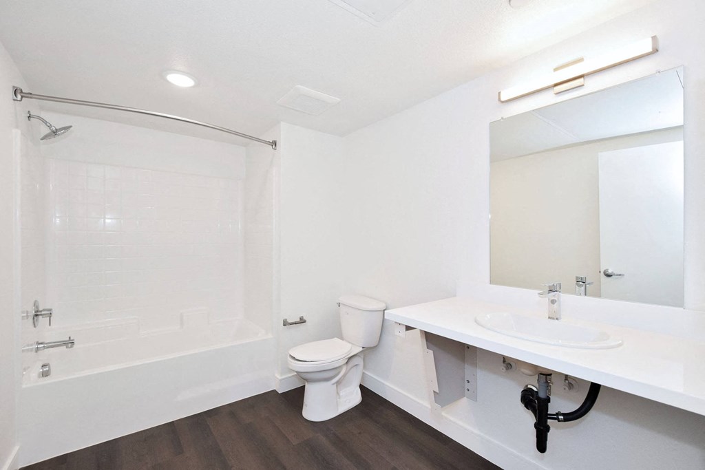 a bathroom with a toilet sink and tub and a mirror