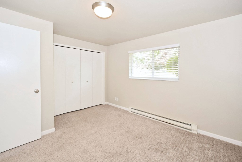 an empty room with white walls and a window