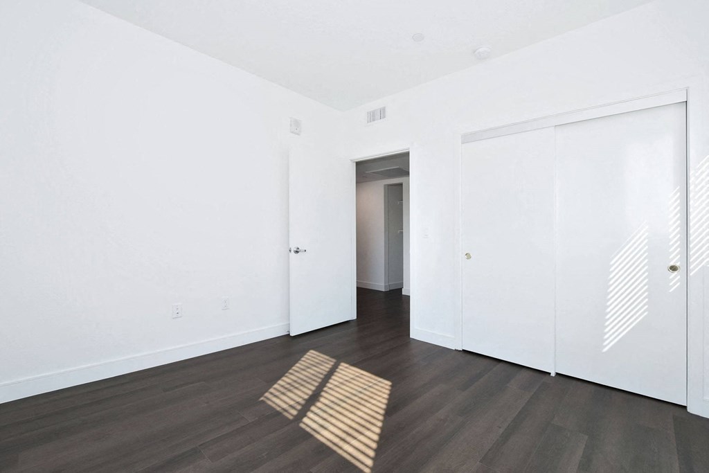an empty living room with white walls and wood floors