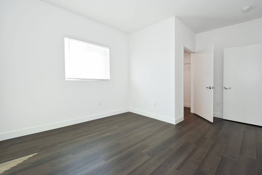 a room with white walls and chairs and wooden floors