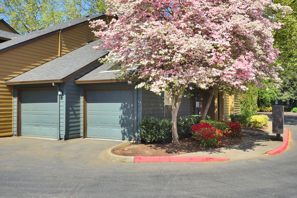 a house with blue garage doors and a flowering tree in front