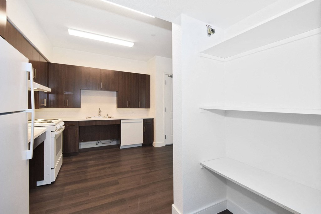 a renovated kitchen with white appliances and wood floors