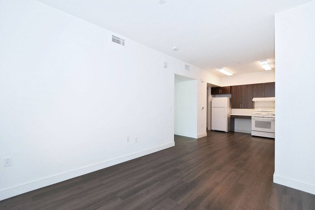 an empty room with white walls and wood floors