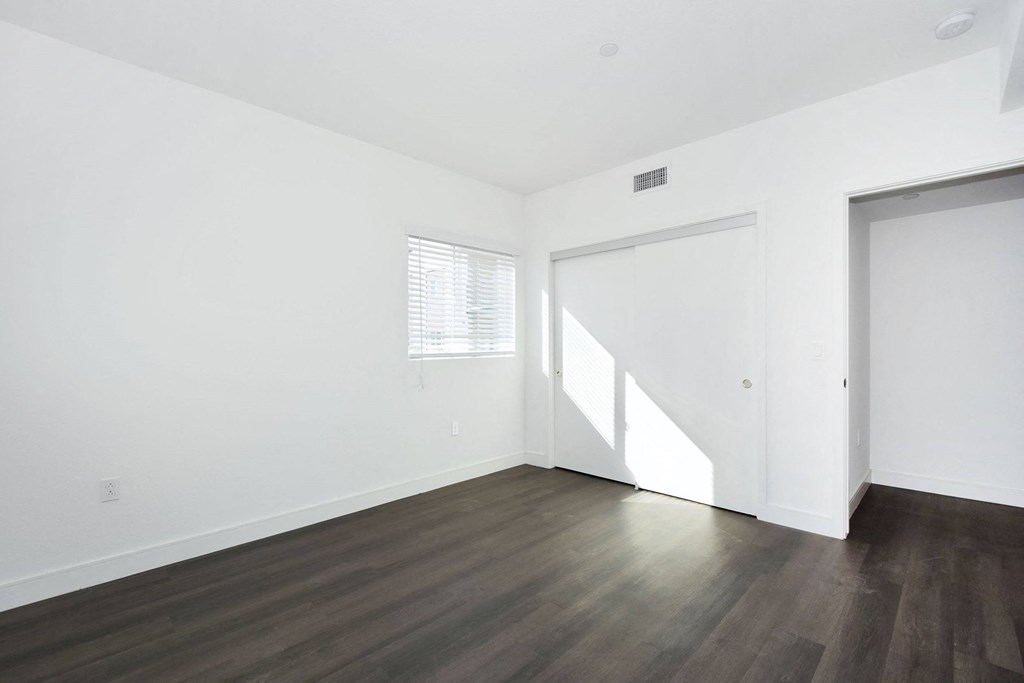 an empty living room with white walls and wood floors
