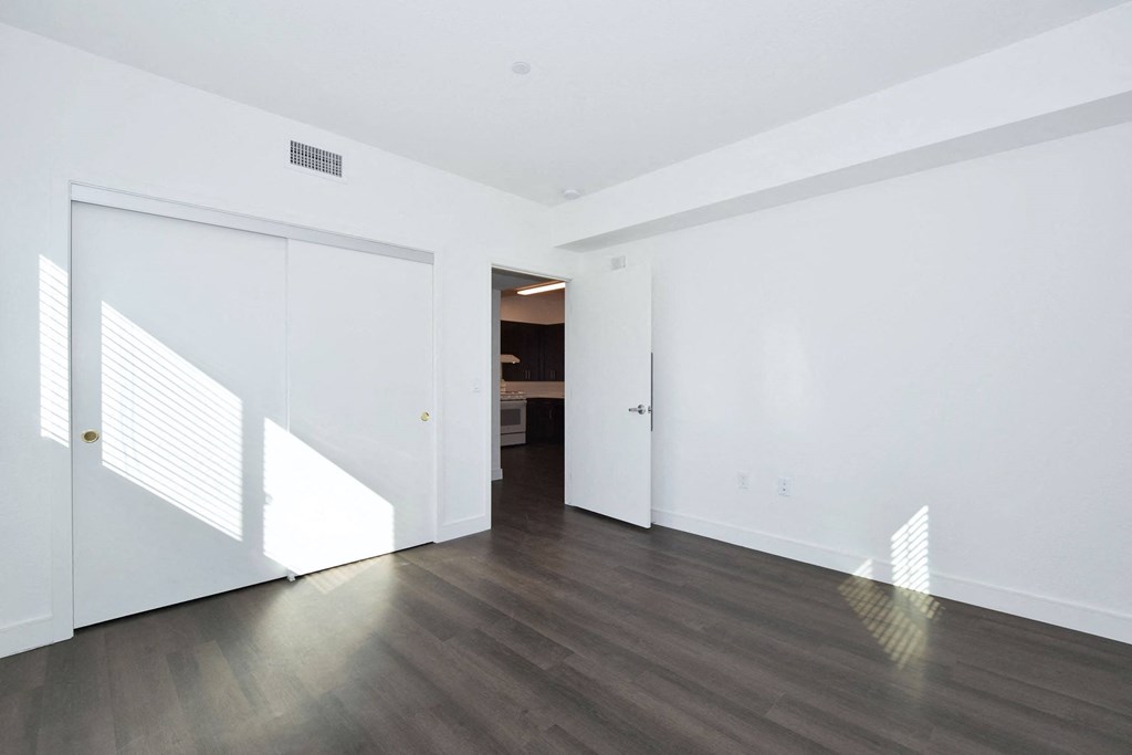 an empty living room with white walls and wood floors