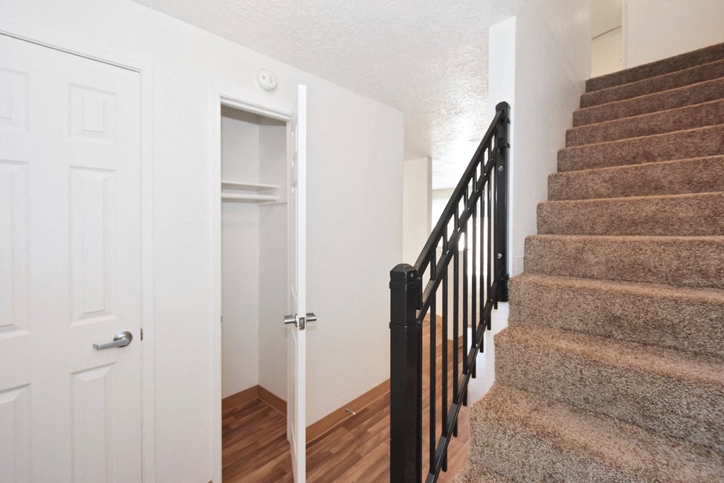 the entryway of a home with stairs and a door to a closet and a