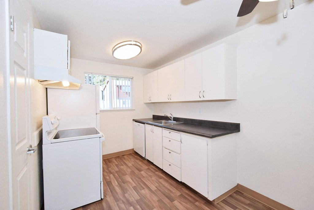 a kitchen with white cabinets and a sink and a refrigerator