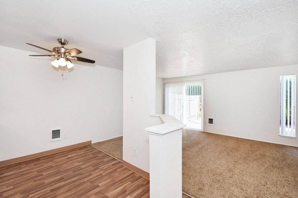the spacious living room and dining room with a ceiling fan