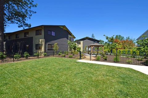 A modern house with a well-maintained lawn and a fence.