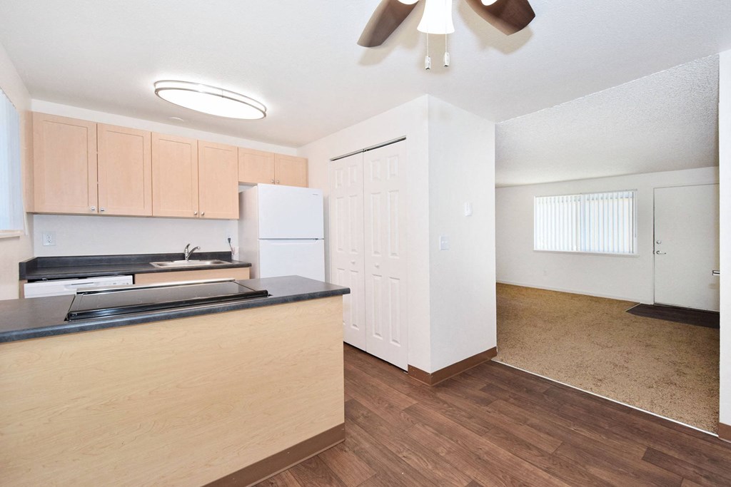 an empty kitchen with a counter top and a refrigerator
