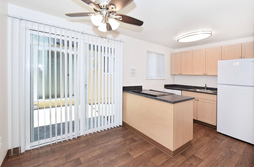 a renovated kitchen with a window and a ceiling fan