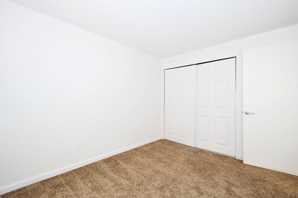 a bedroom with a door and carpeted floor