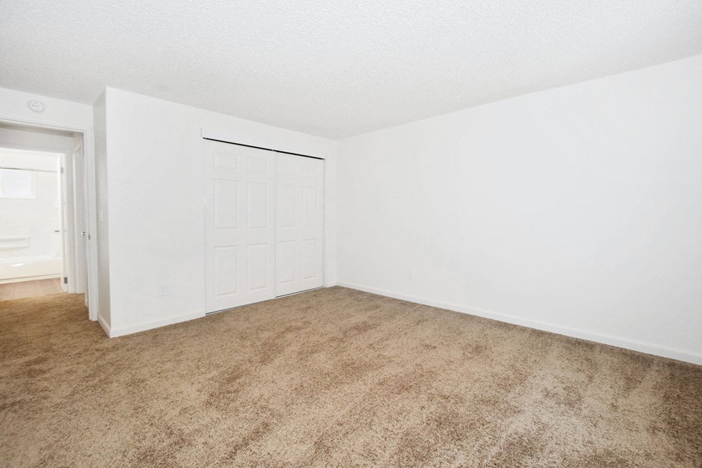 an empty living room with white walls and a white door