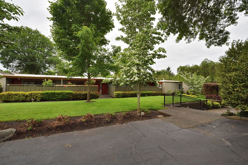 the front of a house with a yard and trees