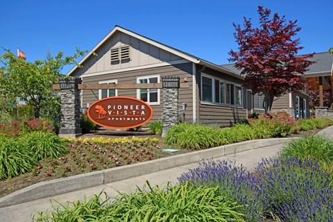 A building with a sign that says Pioneer Village Apartments.