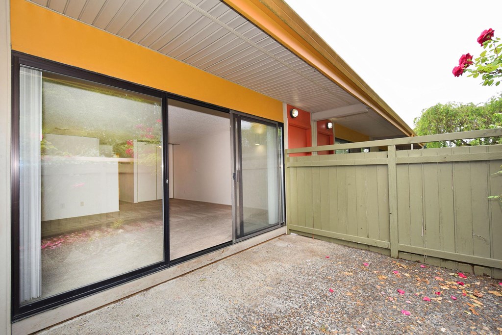 a patio with sliding glass doors and a fence