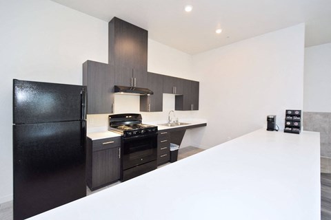 a kitchen with a white counter top and black appliances
