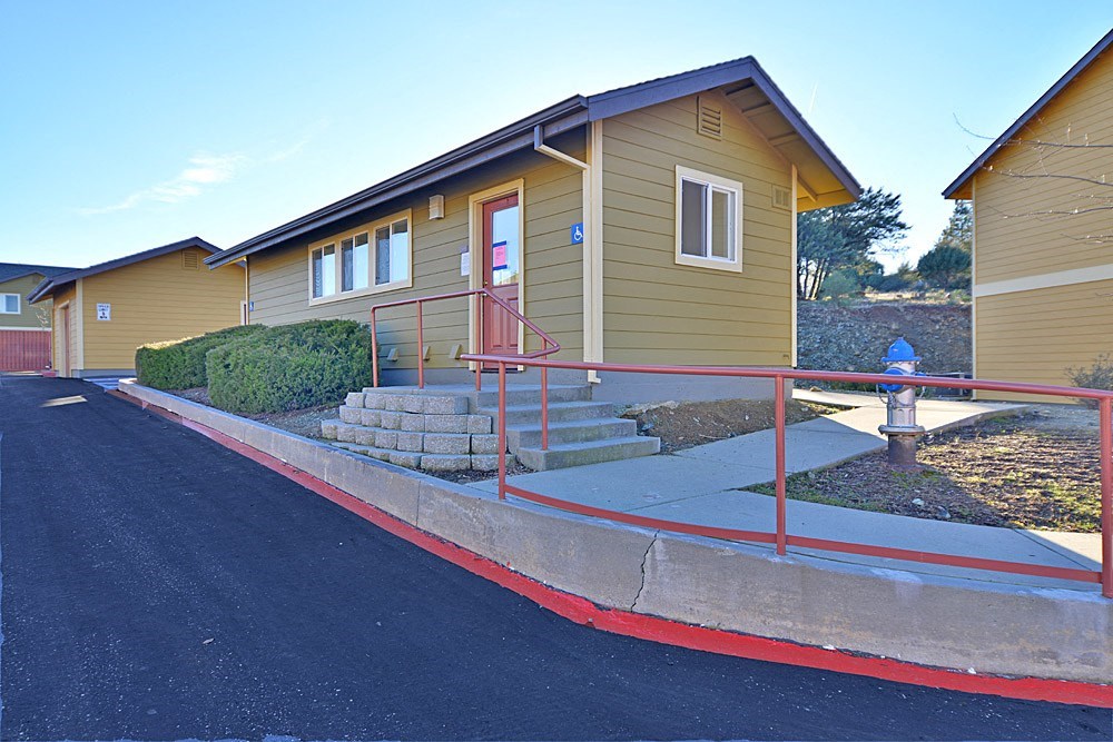 a yellow building with a red door and a blue fire hydrant in front of it