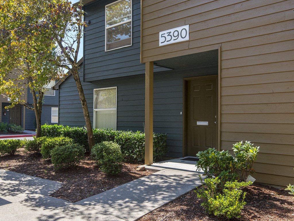 a side view of a building with a door and a sidewalk