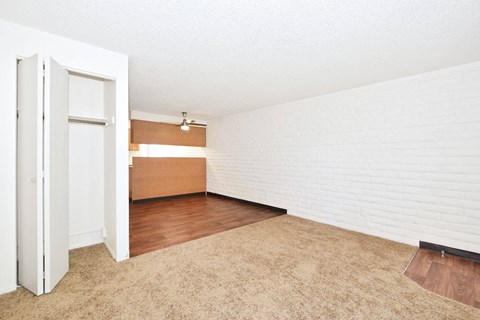 an empty living room with white walls and wood flooring