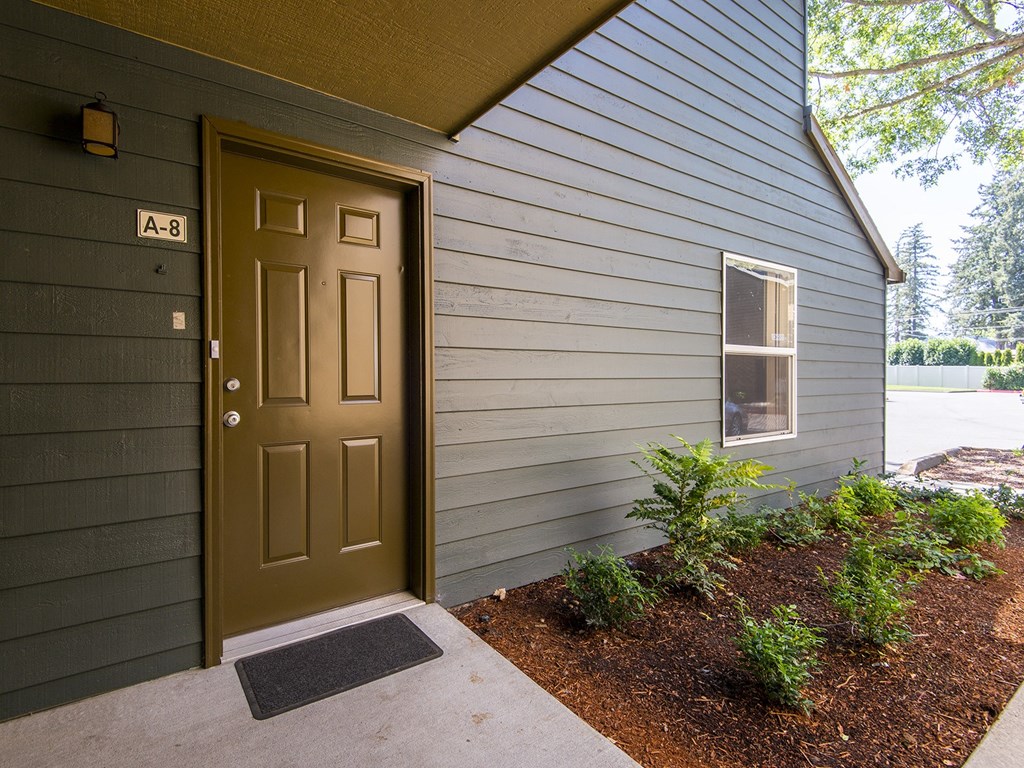 the front door of a home with a sidewalk and a door open
