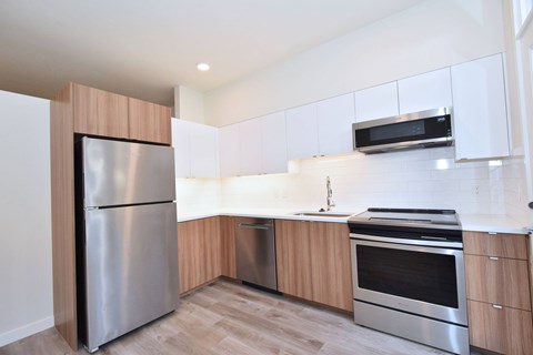 A modern kitchen with a stainless steel refrigerator and oven.