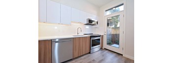 A kitchen with white cabinets and a stainless steel dishwasher.