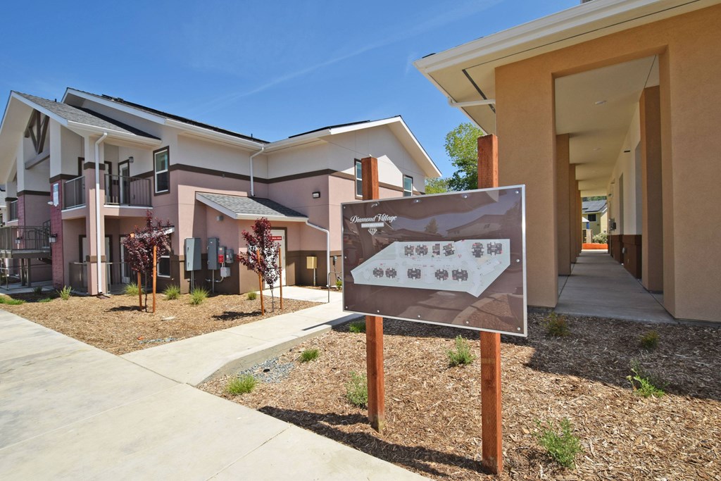 A sign in front of a building with a clear blue sky in the background.