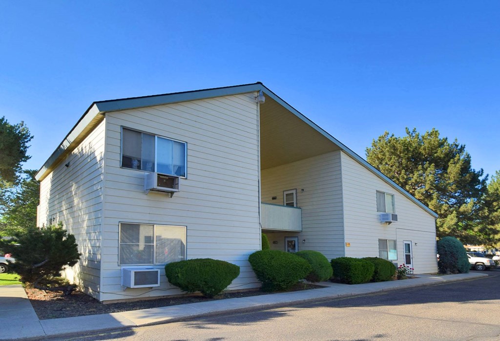 A two-story building with a beige exterior and a dark roof.